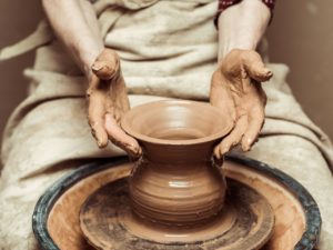 Close up of female hands working on potters wheel